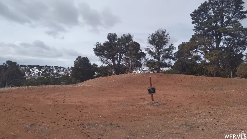 Expansive undeveloped land with a red soil composition, offering a natural setting