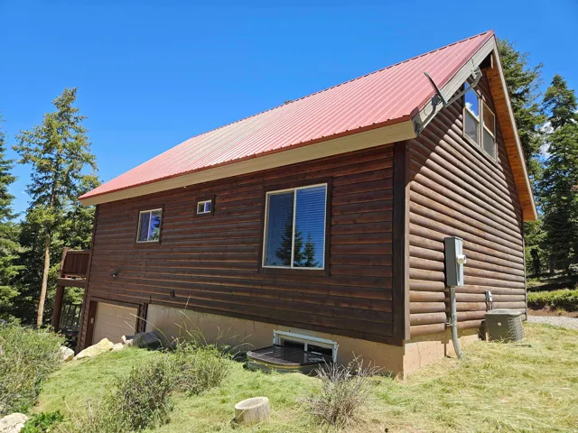 Log cabin exterior with a red corrugated metal roof