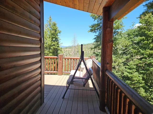Expansive outdoor deck featuring wood-finish flooring and a log railing system