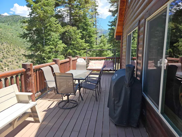 Expansive outdoor deck with sturdy wood railings, composite decking, and sliding glass doors