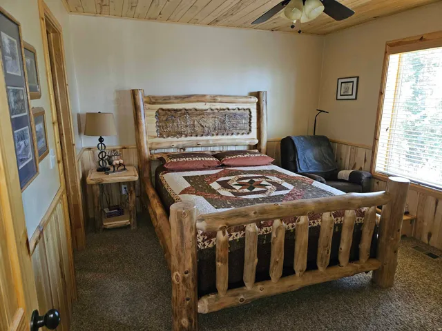 Bedroom featuring a wood-panel accent wall and a matching wood-paneled ceiling