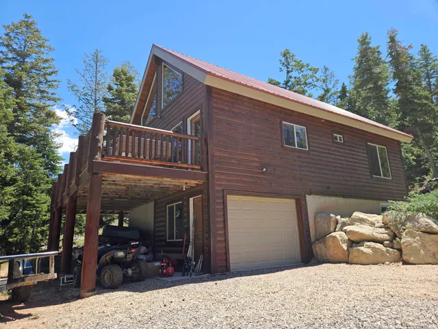 Rustic wood-sided dwelling with a red metal roof and A-frame architectural elements