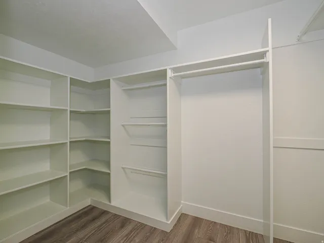 Expansive built-in closet system featuring multiple shelving units and hanging rods