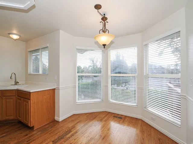 Bay window with multiple panels, wood-finish flooring, recessed lighting, and a pendant light fixture