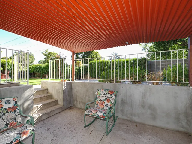 Covered patio area featuring a corrugated metal ceiling and concrete flooring