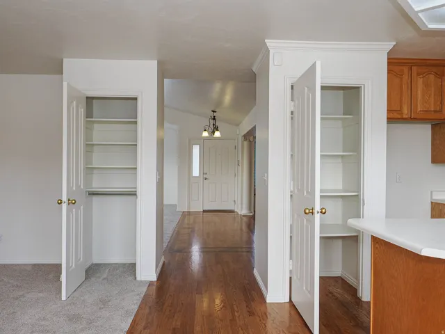 Hardwood-finish flooring, built-in shelving, white paneled doors, and ceiling light fixtures