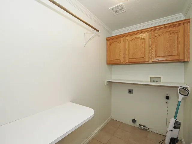 Laundry area featuring wood cabinetry, a utility sink rough-in, and tile flooring