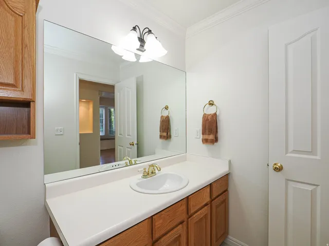 Vanity with wood-finish cabinetry and a single basin sink