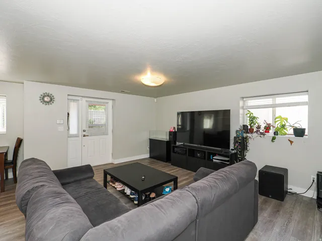 Wood-finish flooring throughout, light gray walls, white trim, and a white exterior door with glass paneling