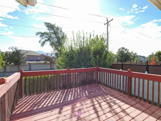 Wood deck with red-stained railing, offering outdoor living space