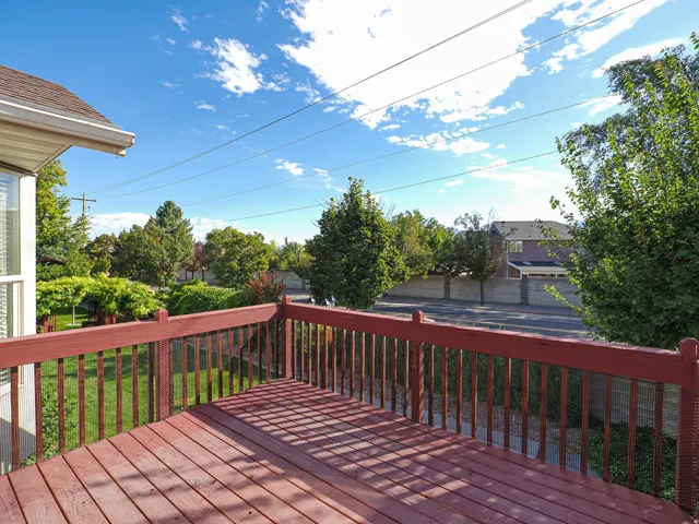 Expansive wood-finish deck with a red railing