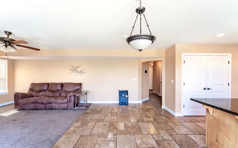 Open-concept living area featuring a mix of carpet and large format tile flooring