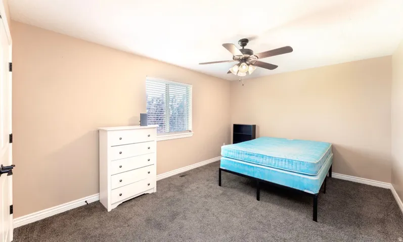 Neutral-toned room with plush carpeting and white baseboards