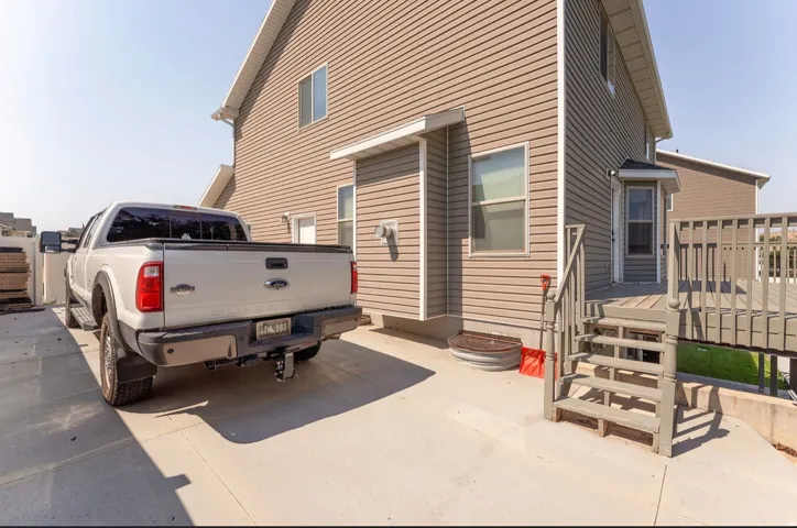 Exterior siding with multiple windows and a multi-level deck featuring railings and steps