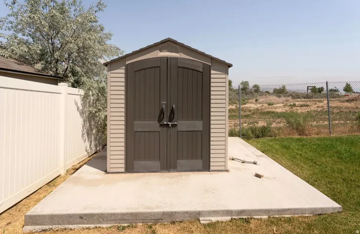 Storage shed featuring double doors and a gabled roof
