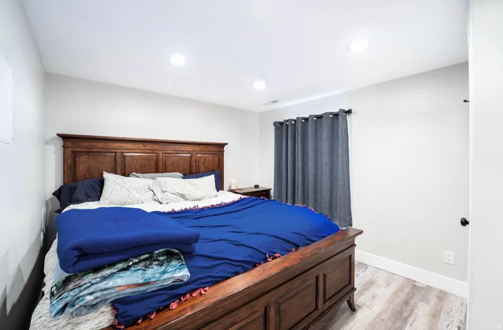 Spacious room with light-colored walls and wood-finish flooring