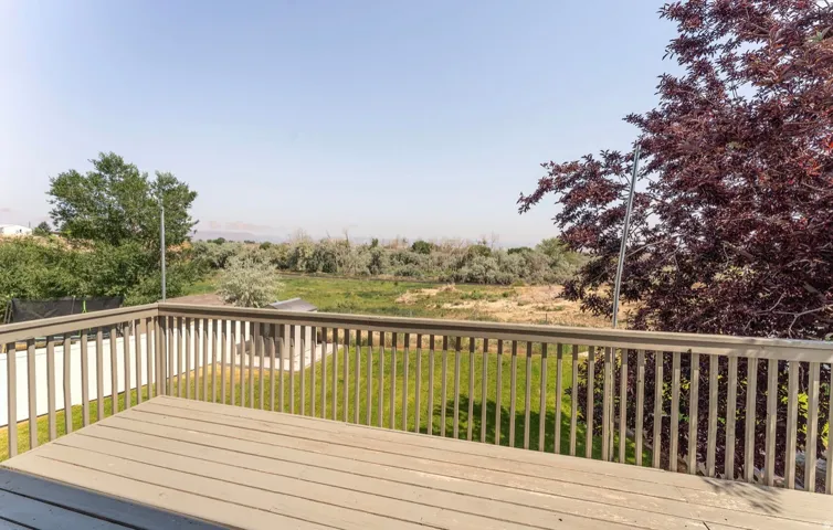 Expansive outdoor deck featuring wood-finish flooring and a full railing system