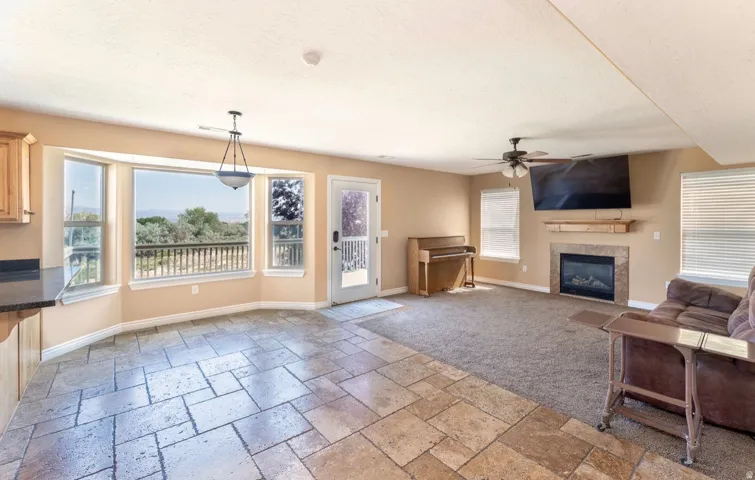 Spacious interior featuring a bay window, tile flooring, and a fireplace with a stone surround