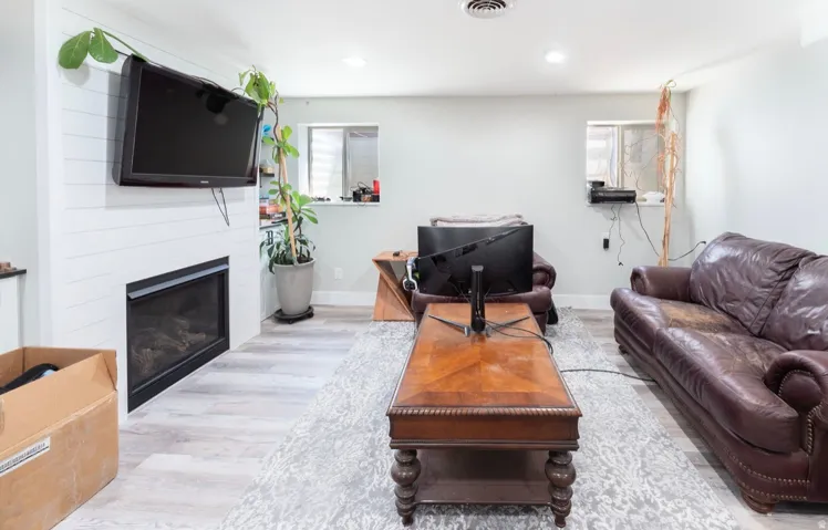 Living area featuring a modern fireplace with a white shiplap surround