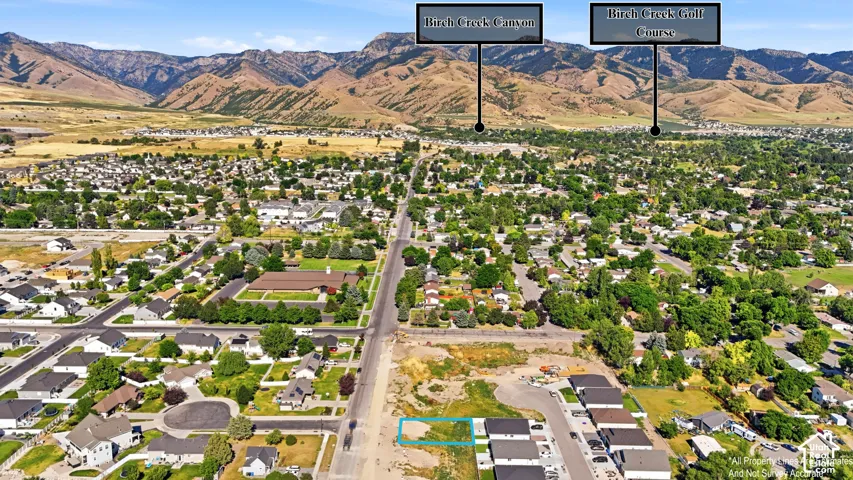 Aerial perspective of a developed neighborhood with surrounding mountainous terrain