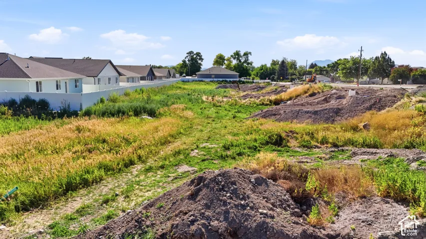 Expansive undeveloped land featuring varied terrain with visible soil mounds and natural vegetation