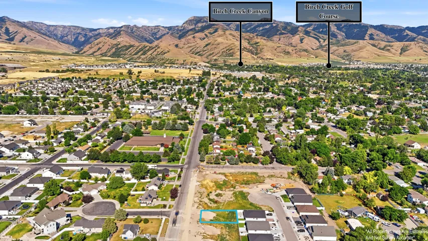 Aerial perspective of a developed neighborhood with surrounding mountainous terrain