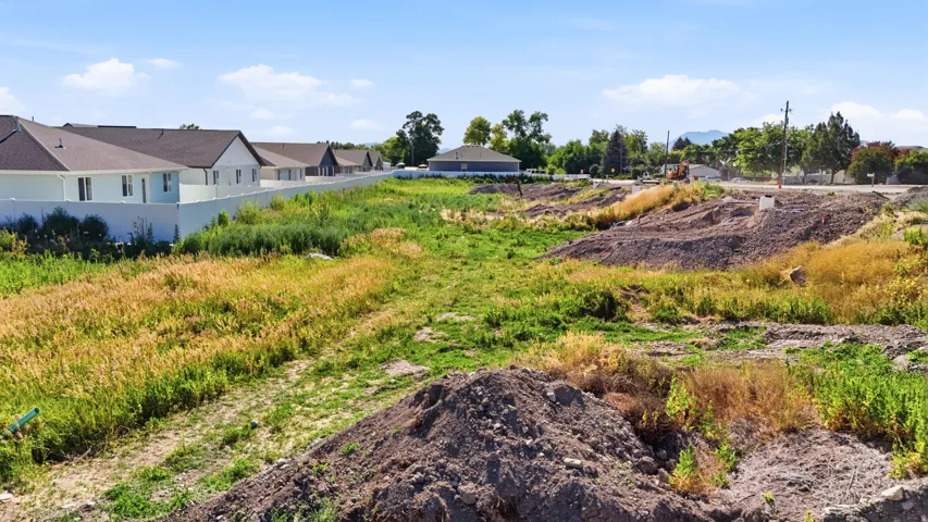 Expansive undeveloped land featuring varied terrain with visible soil mounds and natural vegetation