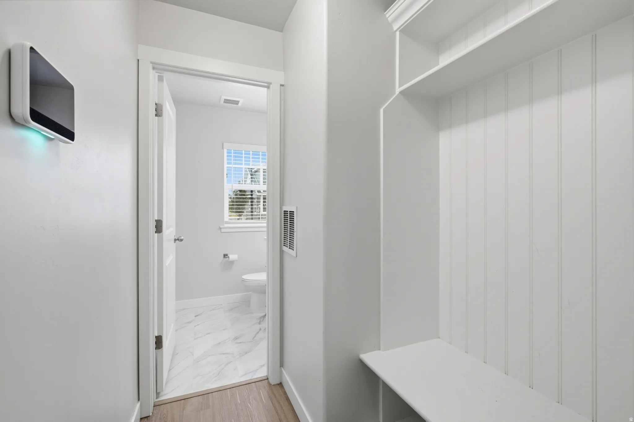 Built-in mudroom bench with vertical paneling, offering integrated storage and seating