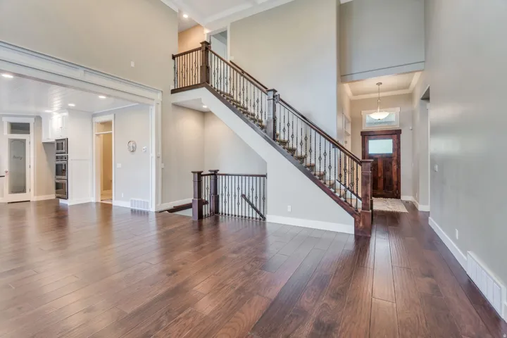 Grand foyer featuring a dark wood-finish front door with privacy glass, a two-story ceiling, and a chandelier