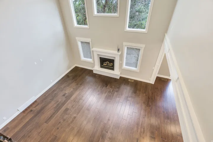 Open-concept living area with soaring ceilings and wood-finish flooring
