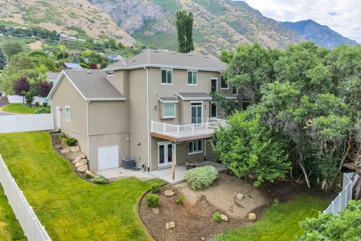 Multi-level residence featuring a stucco exterior, composition shingle roof, and a white fenced yard