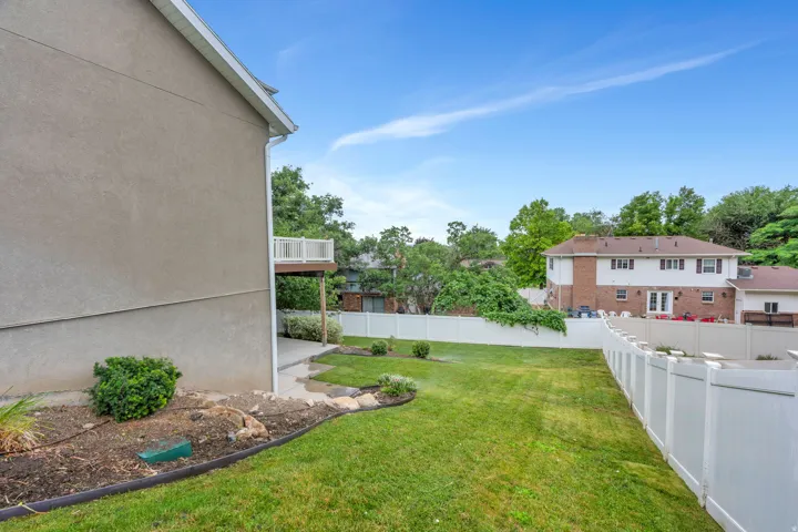 Expansive green lawn outlined by a white privacy fence