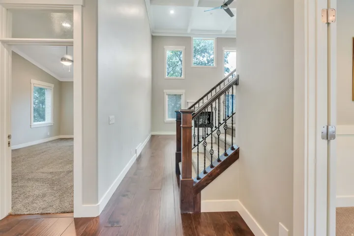 Open concept living space featuring wood-finish flooring and a staircase with wrought iron balusters