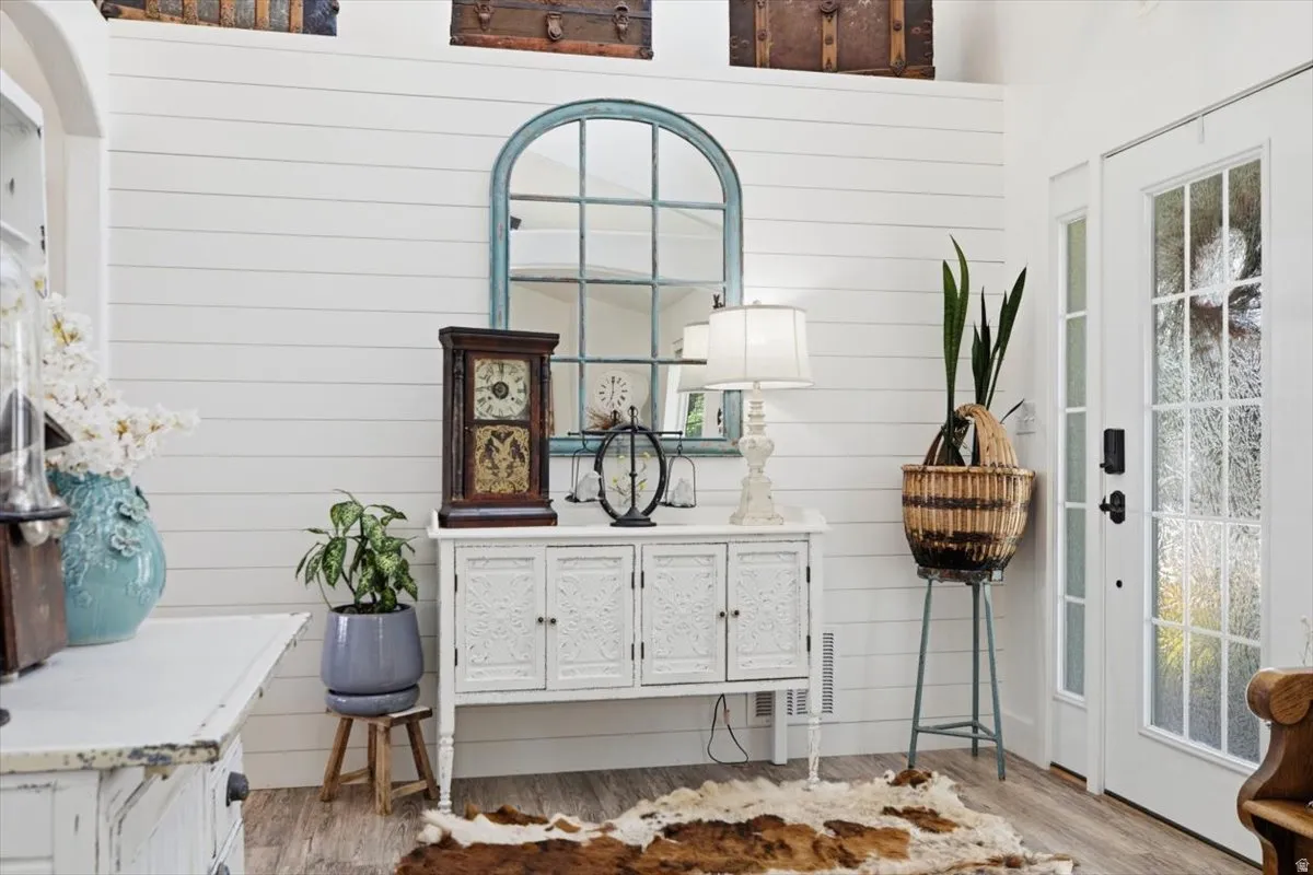 Entryway featuring shiplap walls, wood-finish flooring, and a glass-paned door