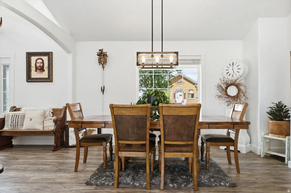 Dining area featuring wood-finish flooring, white walls, and an exposed beam ceiling detail