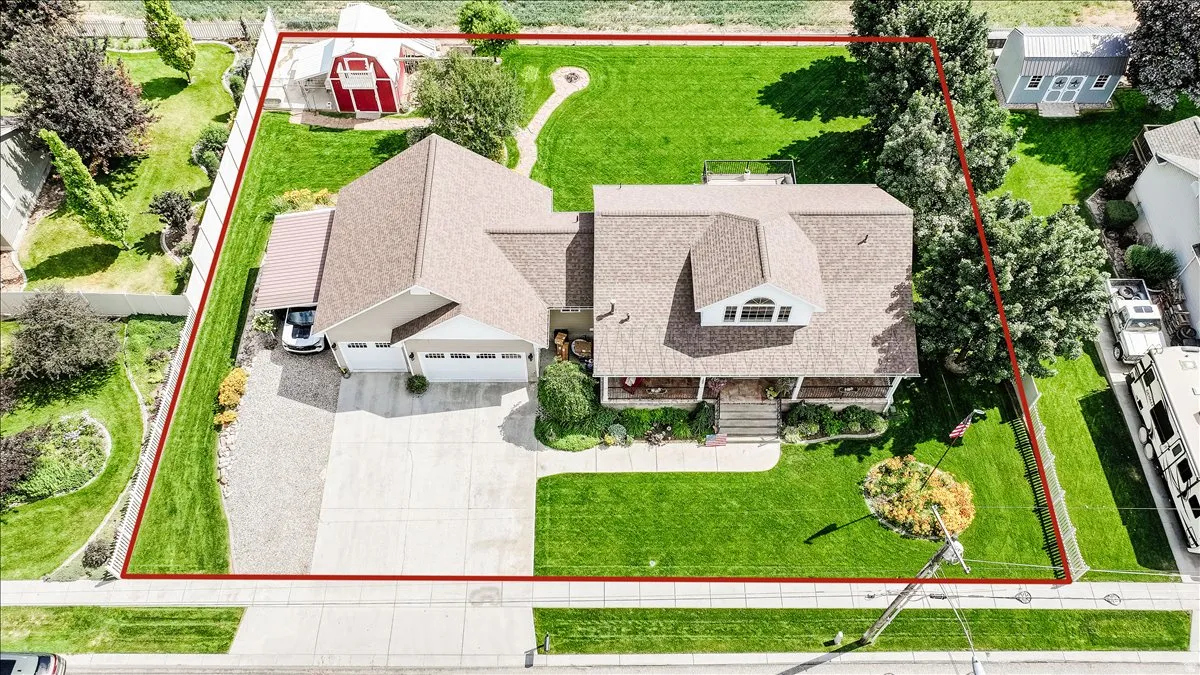 Expansive property featuring a large residence with a multi-gabled roofline, a front porch, and an attached garage