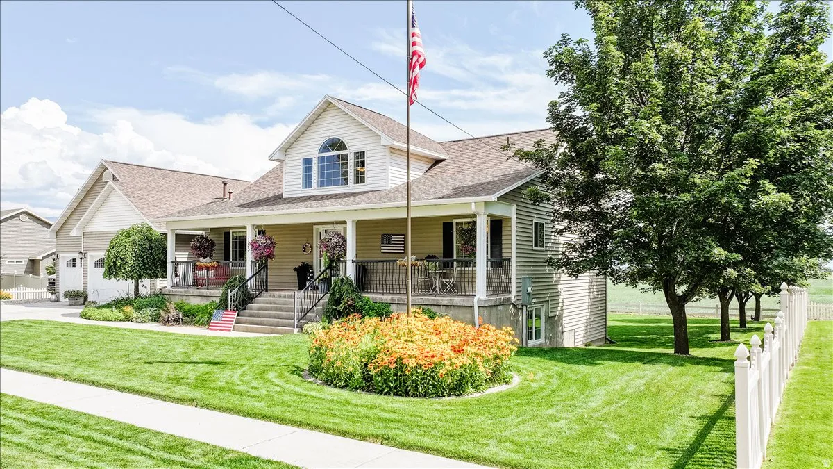Two-story residence featuring a covered front porch, an arched window, and a prominent front-facing gable
