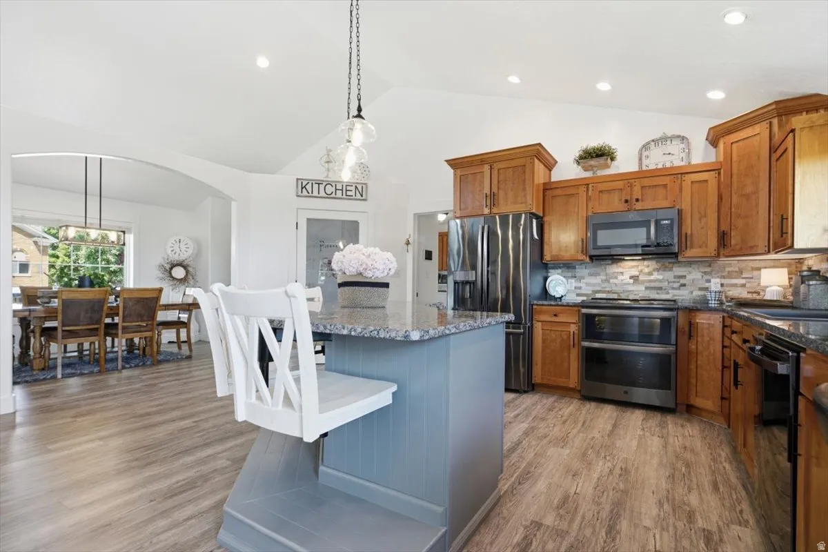 Kitchen featuring a central island with a blue-painted base and stone countertop