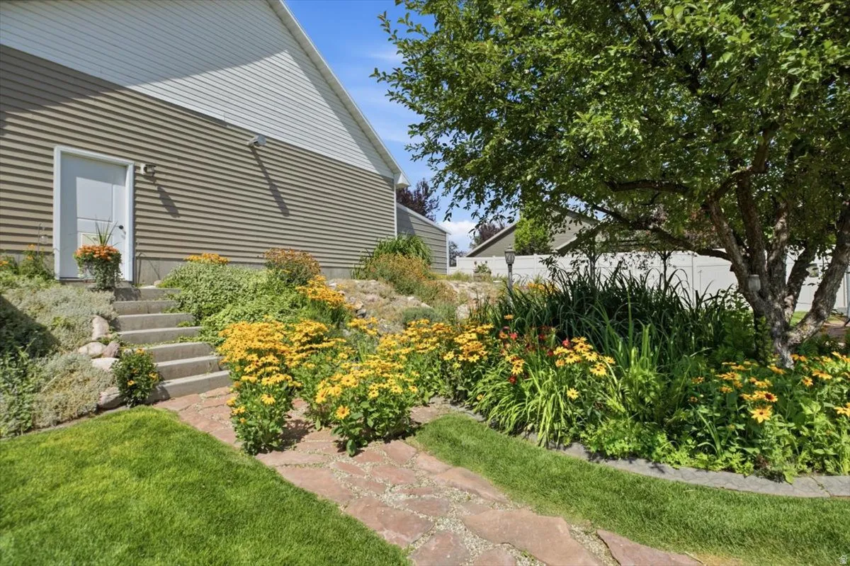 Manicured lawn with a flagstone pathway, mature shade tree, and established garden beds