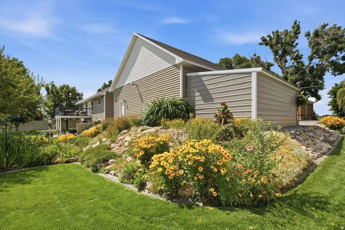 Manicured lawn with a terraced rock garden featuring various flowering plants