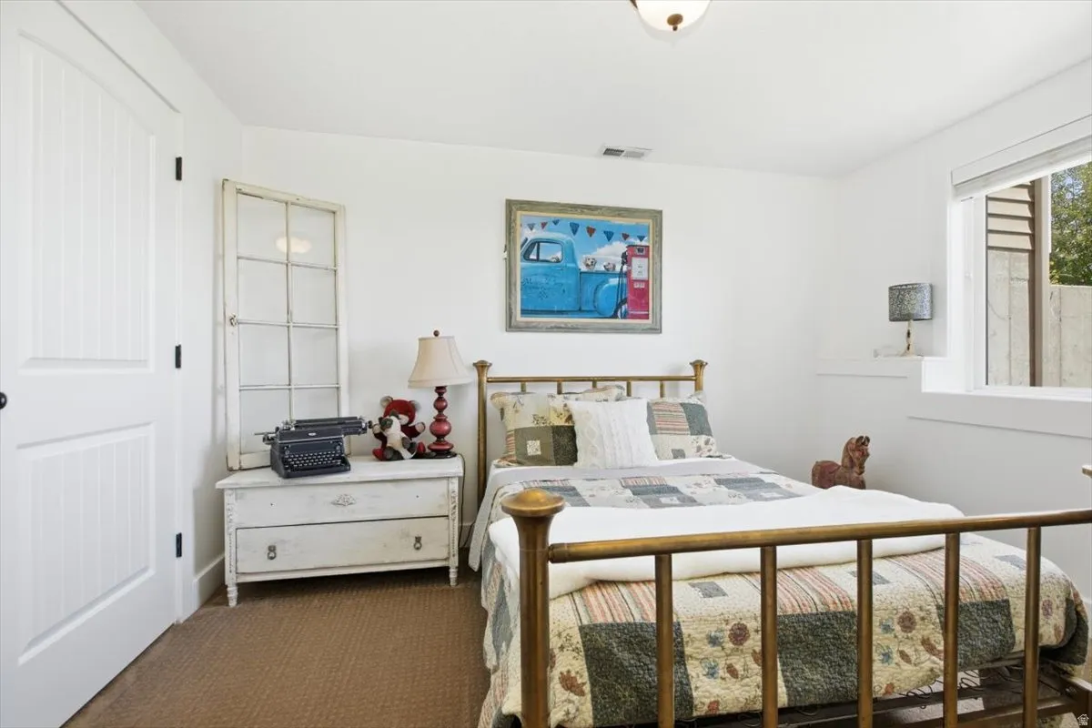 Interior room featuring a white paneled door, a single window, and textured carpet flooring