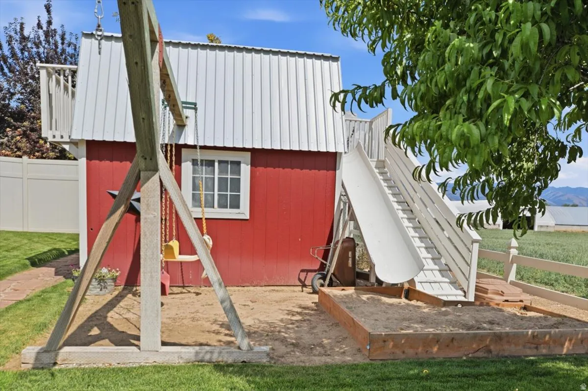 Red barn-style shed with white metal roofing, featuring a second-story balcony