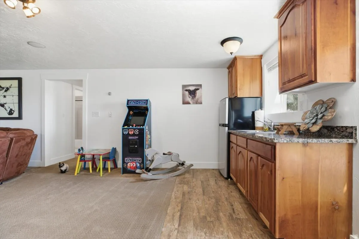 Built-in kitchenette featuring wood cabinetry, granite-finish countertops, and stainless steel appliances