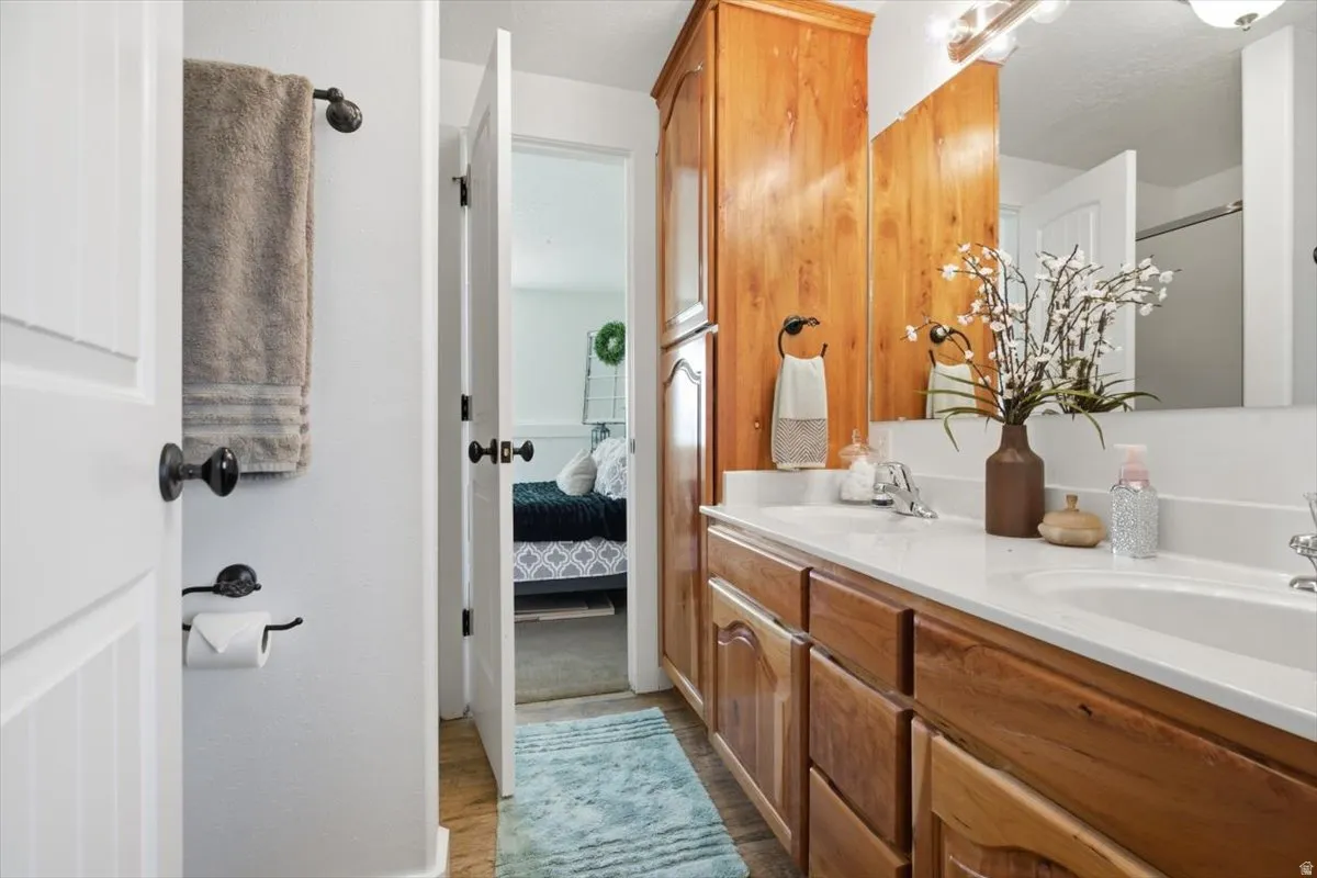 Bathroom featuring a dual-sink vanity with a white countertop and wood-finish cabinetry