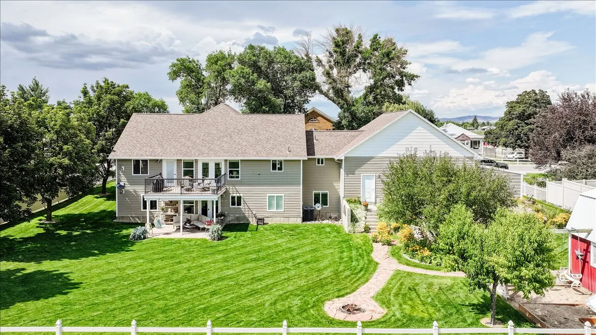 Expansive green lawn with a multi-level deck and covered patio
