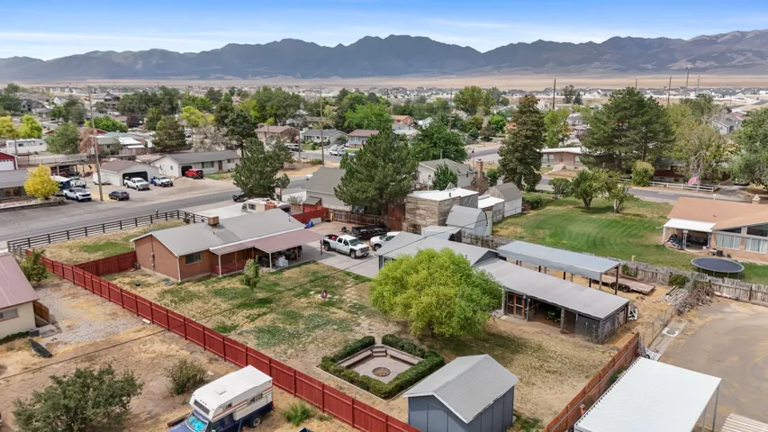 Expansive property featuring multiple outbuildings, mature trees, and a mountain backdrop