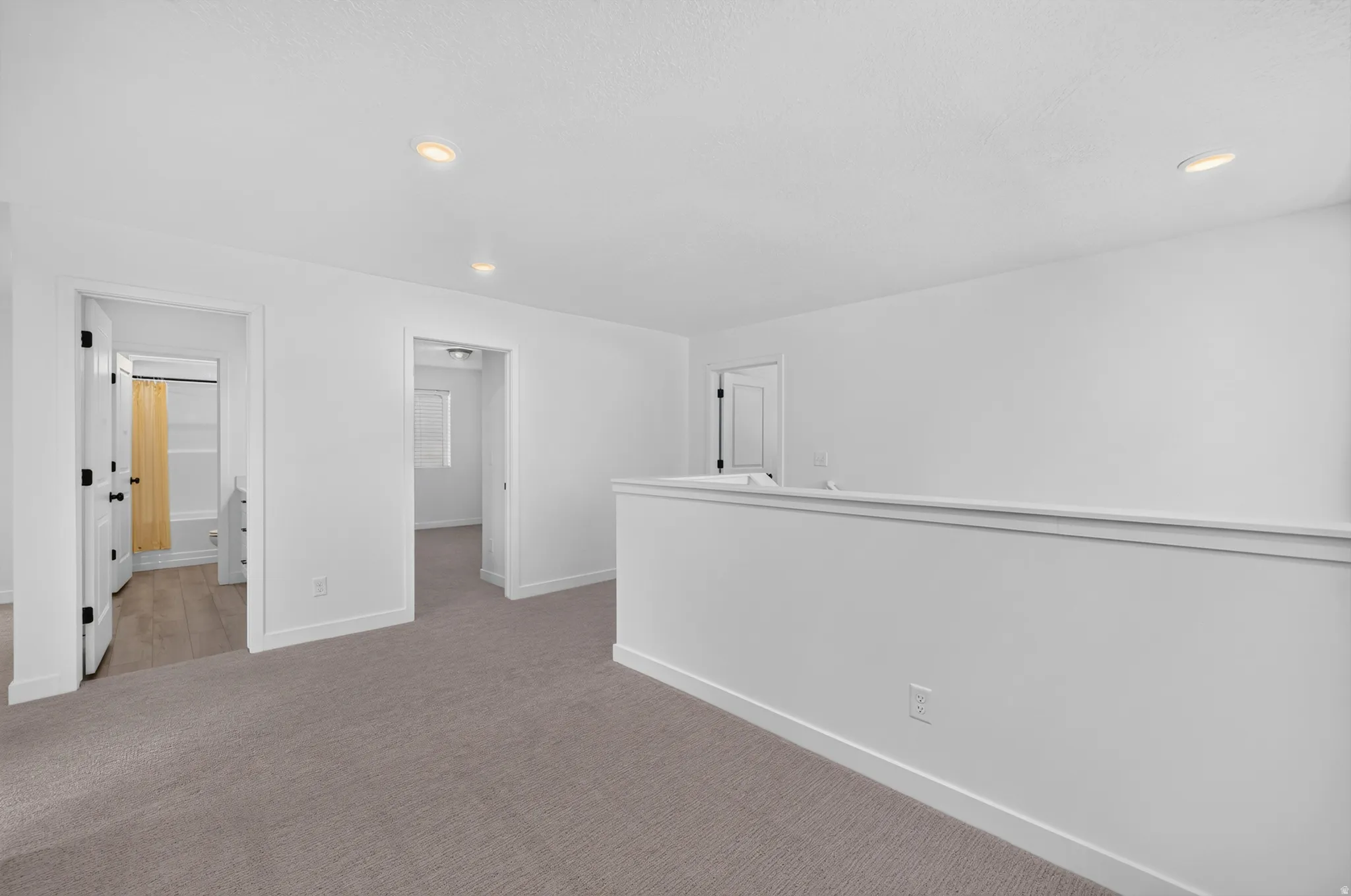 Carpeted landing area featuring recessed lighting and white walls