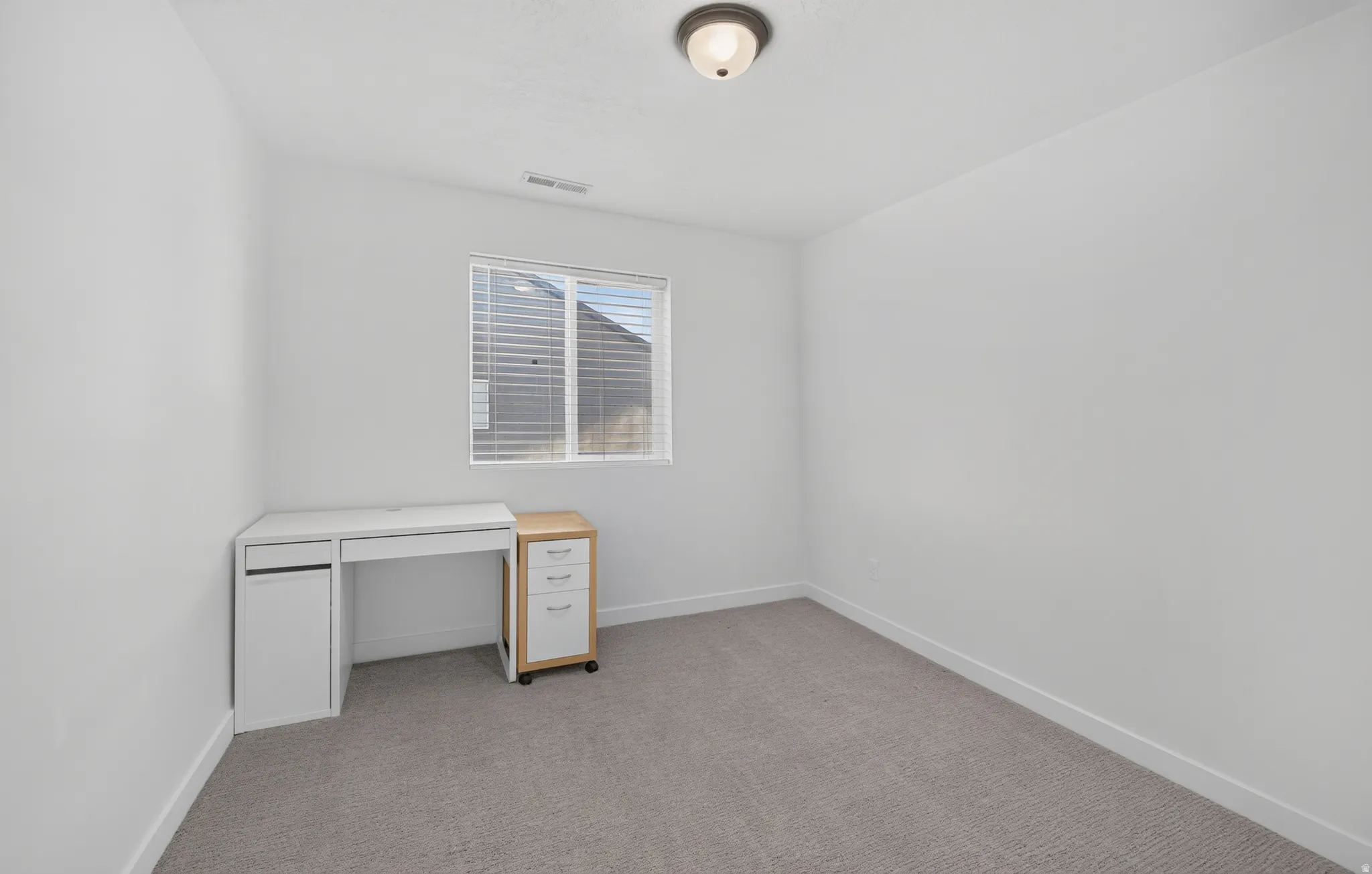 Neutral-toned wall-to-wall carpeting complements the white walls