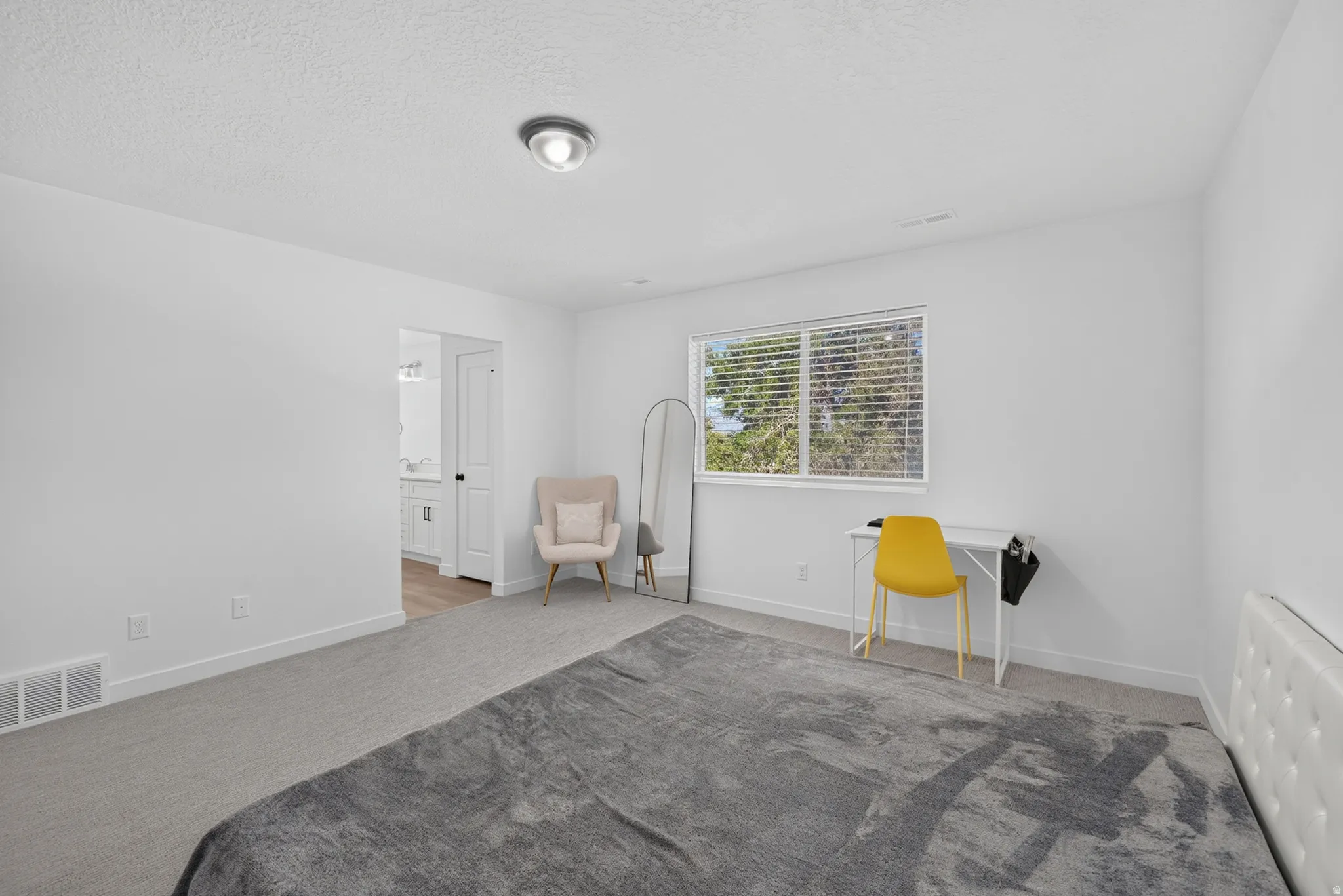 Bright room featuring light grey carpet, white walls, and a recessed window