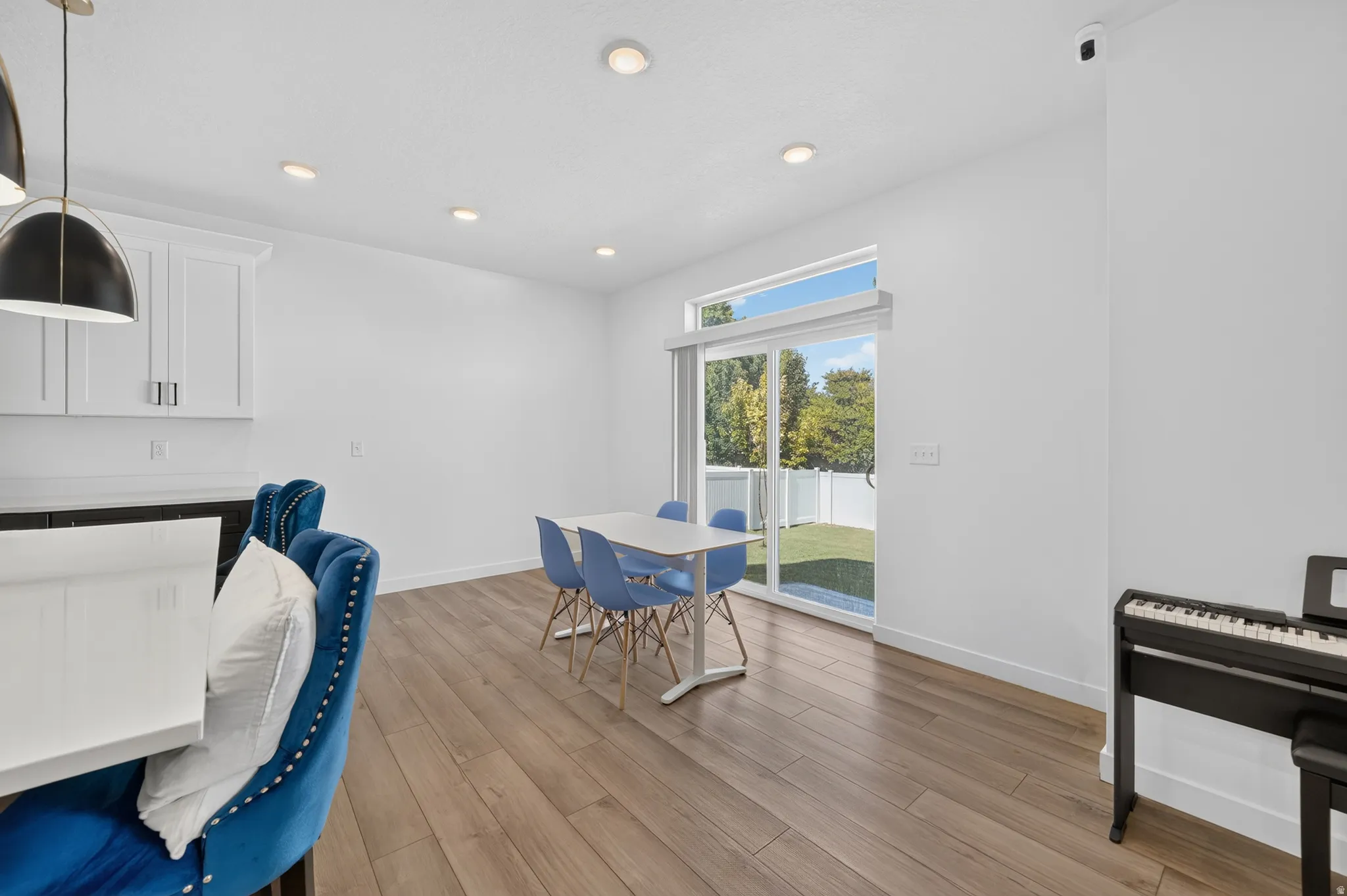 Open-concept living space with wood-finish flooring, recessed lighting, and a sliding glass door to the exterior